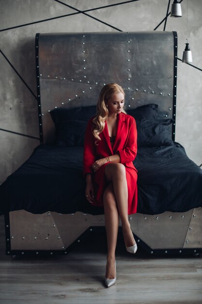 Gorgeous blonde woman in red dress looking at camera.