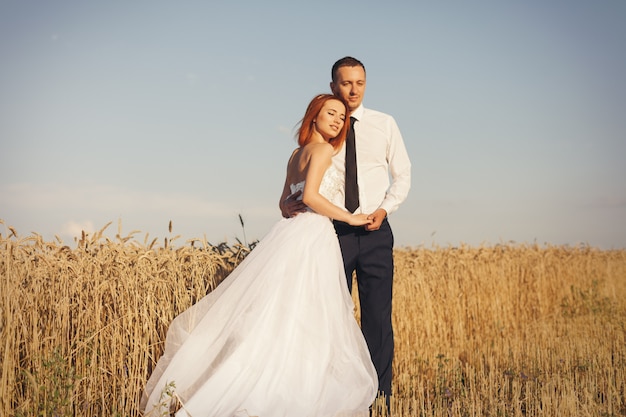 Шикарный жених и невеста в пшеничном поле. Счастье и брак