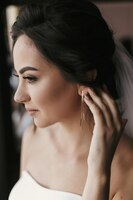 Photo gorgeous bride putting on luxury earrings beautiful woman portrait of getting ready for wedding sensual moment sexy girl posing wedding jewelry accessories