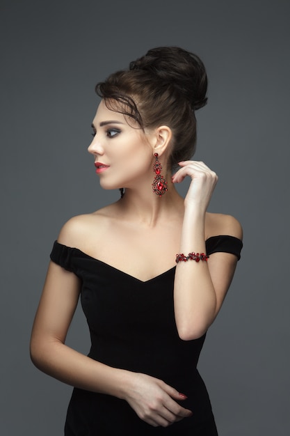 Gorgeous brunette in a black evening dress with jewels