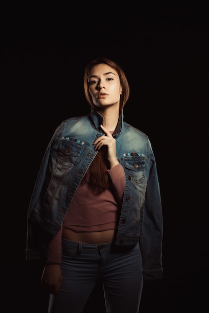 Foto splendida donna bruna con trucco naturale e pelle perfetta che indossa una giacca di jeans alla moda
