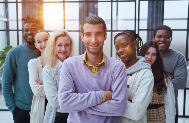 Gorgeous casual man in purple shirt standing with hands on hip looking forward happily