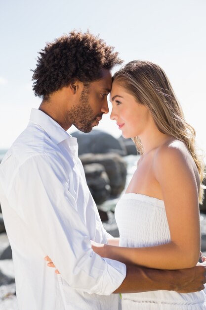 Gorgeous couple embracing by the coast