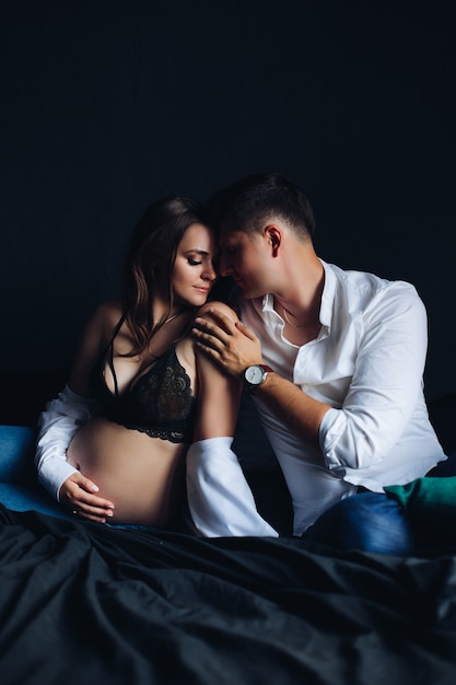 Gorgeous couple with pregnant woman Man touching her shoulder.