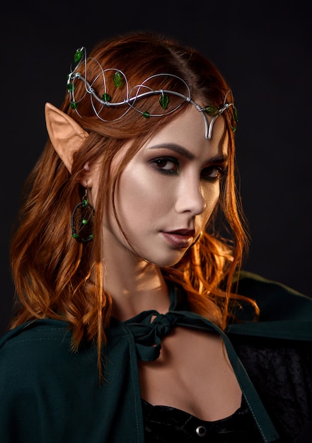 Gorgeous elf in dark green cloak looking at camera.