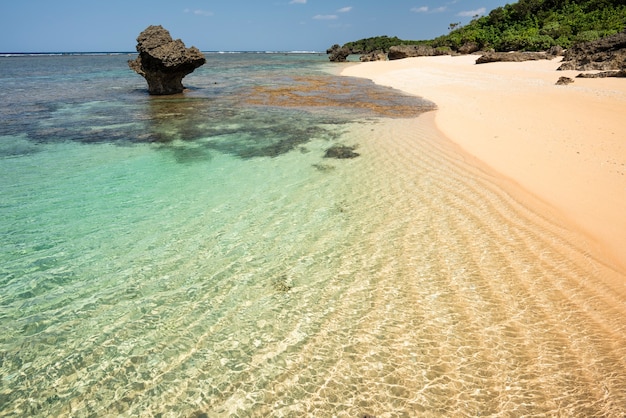 화려한 에메랄드 그린 바다, 물결 모양의 모래, 열대 섬의 전형적인 해안 암석 형성.