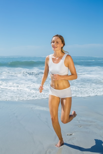 Gorgeous fit blonde jogging by the sea