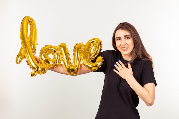 Gorgeous girl holding love balloon and looking at the camera