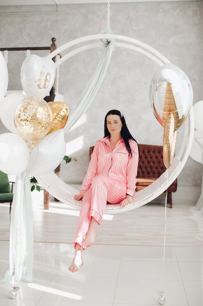 Gorgeous girl in pink pyjamas on hanging chair