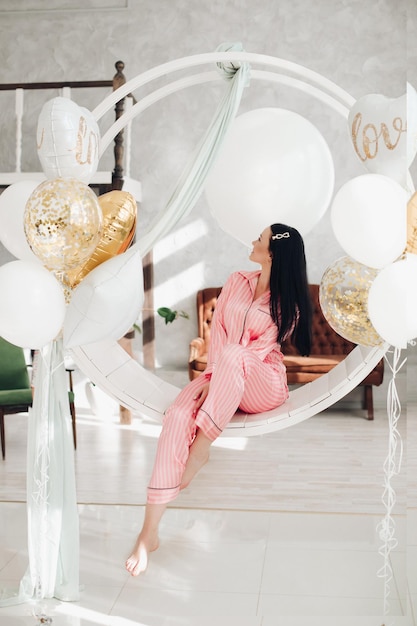 Gorgeous girl in pink pyjamas on hanging chair