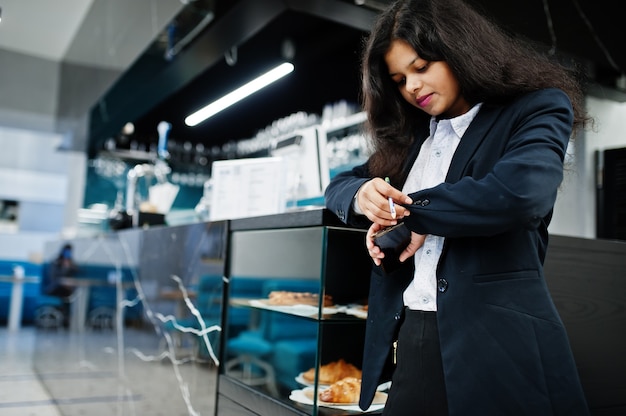 Gorgeous indian woman wear formal posing at cafe near bar counter.