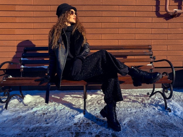 Gorgeous lady sits on the bench outdoors