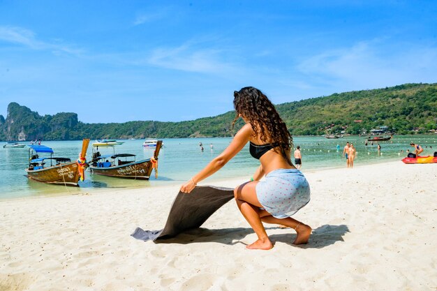 写真 休暇中にビーチでタオルを広げる豪華なレバノンの若い女性