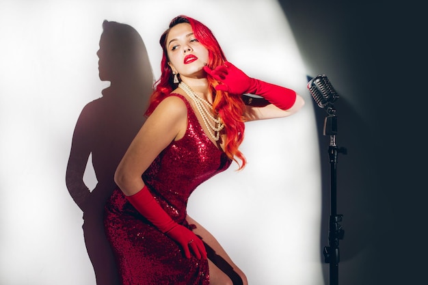 Photo gorgeous red haired woman with retro microphone singing on stage