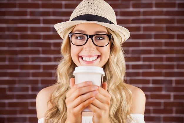 Gorgeous smiling blonde hipster with take-away cup