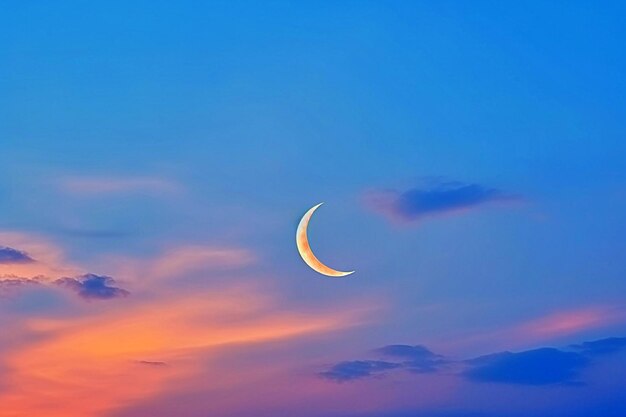 Gorgeous sunfilled overcast black sky crescent moon against a stunning backdrop of the sunset