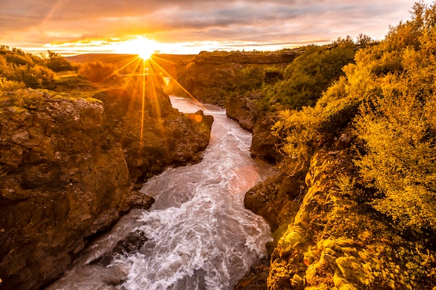 Tramonto splendido sul ponte di legno del fiume barnafoss, islanda