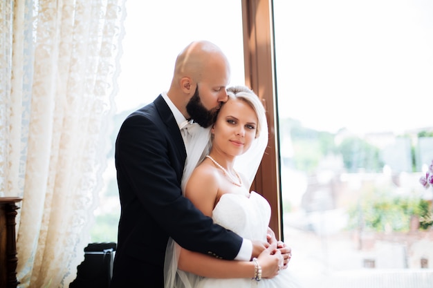 Gorgeous wedding couple enjoys a Sunny day in the old town with architecture