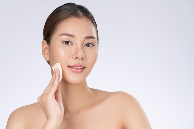 Gorgeous woman applying her cheek with dry powder Beauty care cosmetic concept