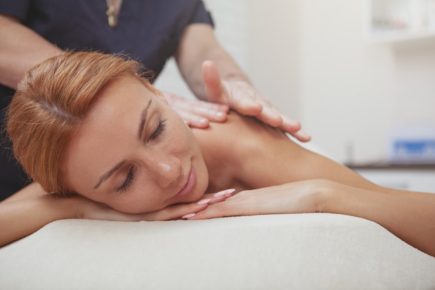 Gorgeous woman enjoying full body massage at spa center