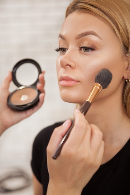 Gorgeous woman getting professional makeup