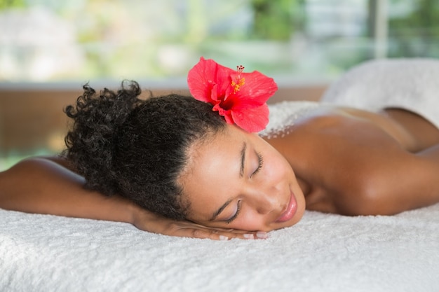 Foto splendida donna sdraiata sul lettino da massaggio con trattamento del sale sul retro