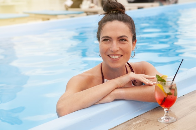 Donna splendida che si rilassa alla piscina