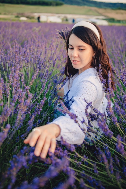 Gorgeous woman in white dress at lavender field sunset time