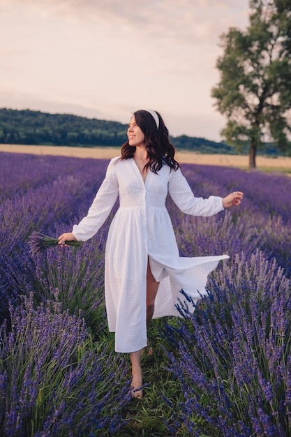 Gorgeous woman in white dress at lavender field sunset time