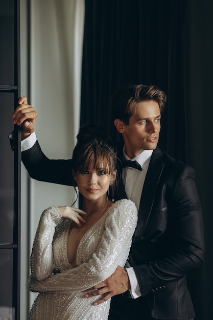 Photo gorgeous woman with red lips and big eyes stands with man in hotel room