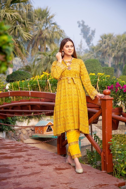 Gorgeous Young Girl Playing with Her Hairs in Park Wearing Stylish Yellow Dress for Fashion Shoot