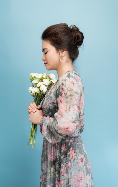 Gorgeous young woman in cute retro dress over blue background