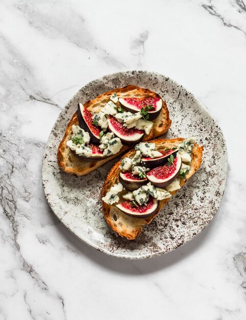 Foto bruschetta al miele di timo e fichi al gorgonzola su sfondo chiaro vista dall'alto