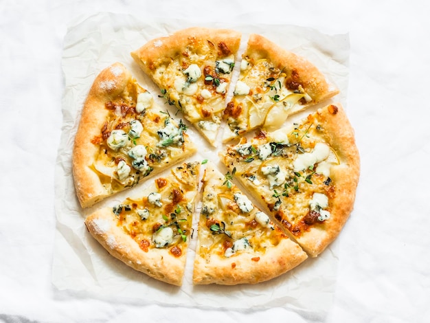 Gorgonzola pears thyme crispy pizza on a light background top view Delicious snacks