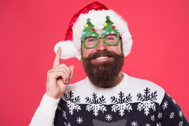 Got idea for winter holidays happy santa keep finger raised red background bearded man smile with winter party look festive winter style new year celebration merry christmas winter season