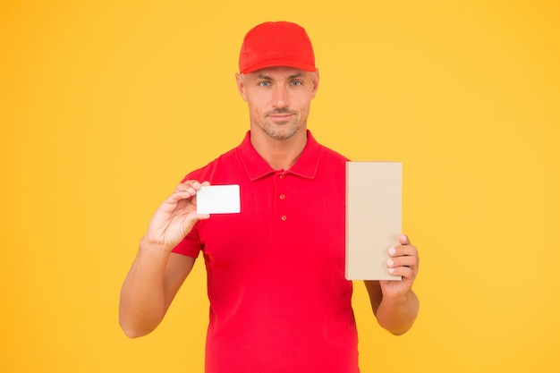 Photo got loyalty card. courier hold discount card and box. parcel delivery. handsome man show blank card for business information. online shopping. shop and pay with credit card, copy space.