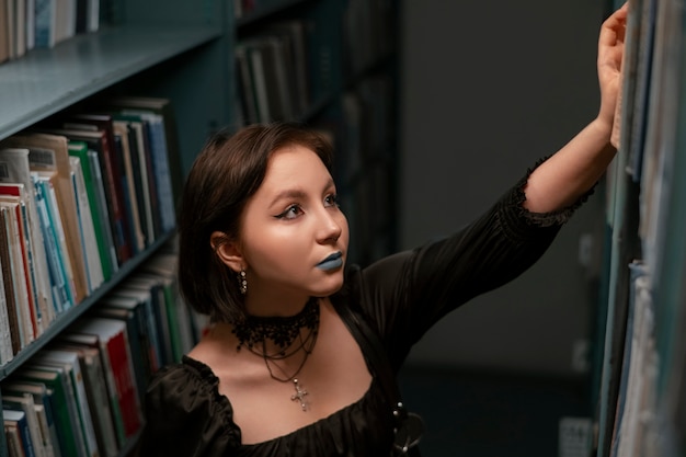 Foto studente gotico nella biblioteca della scuola