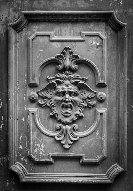 Gothic mask on an old wodden door in Milan - Italy