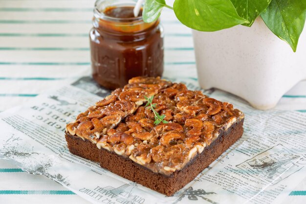 Foto goudbruin vierkant van plakje toffeecake topping cashewnoot en karamelsaus