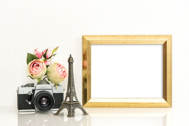 Gouden afbeeldingsframe, roze bloemen en vintage camera. Parijs reisconcept