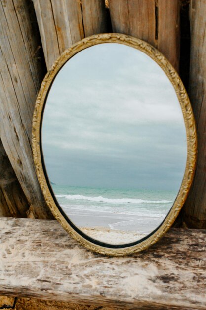 Foto gouden antieke spiegel die de zee weerspiegelt