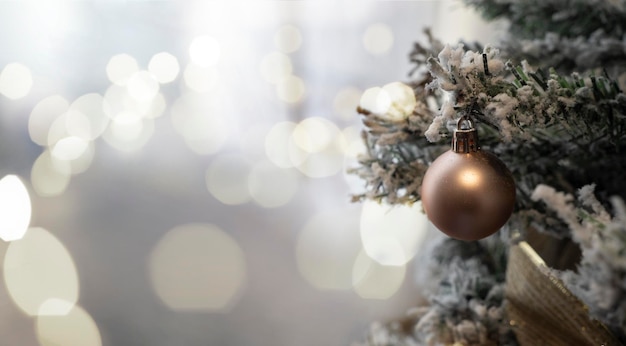 Gouden bal op kerstboom met bokehachtergrond