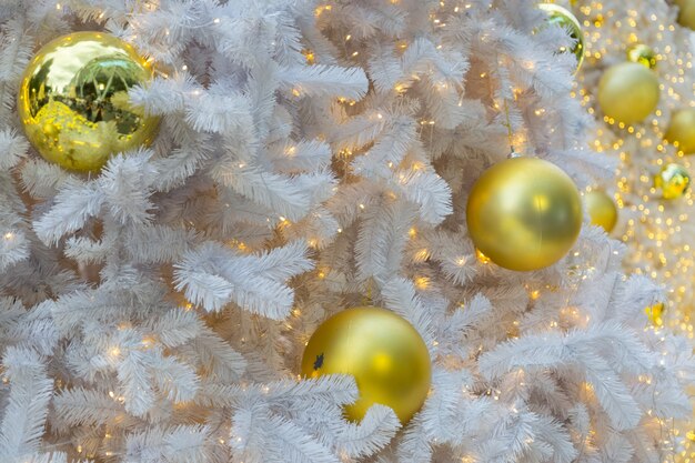 Gouden bal op witte kerstboom achtergrond
