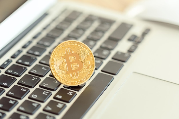 Gouden bitcoin fysiek muntsymbool op toetsenbord