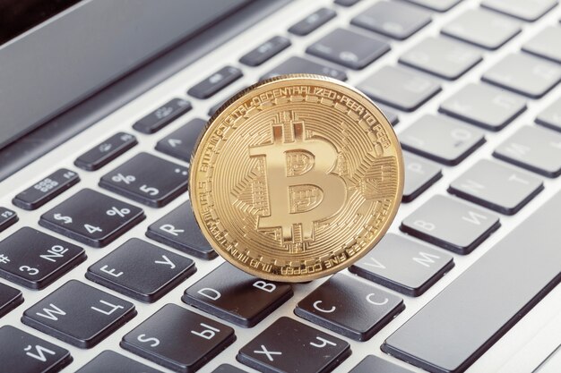 Gouden bitcoin fysieke munt op toetsenbord