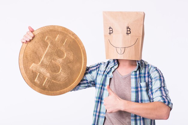 Gouden bitcoin in de hand van een grappige man, digitall-symbool van een nieuwe virtuele valuta.