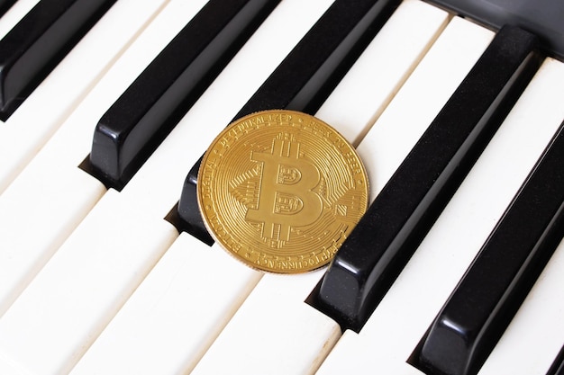 Gouden Bitcoin-munt op pianotoetsen close-up