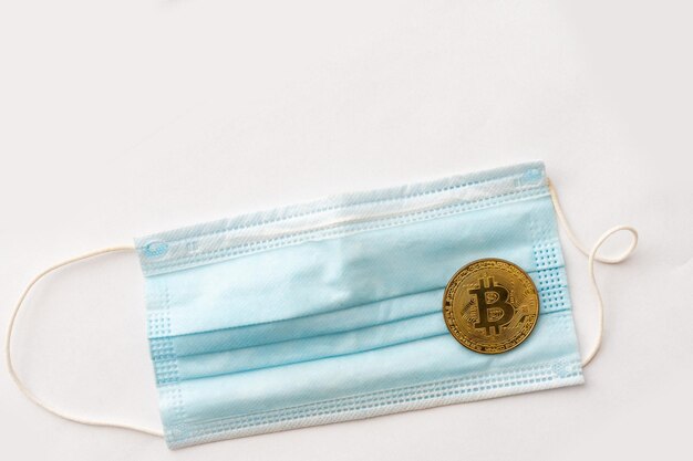 Gouden Bitcoin-munten met een medisch masker