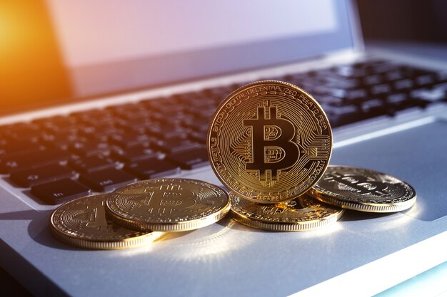 Gouden bitcoin-munten op het toetsenbord van de laptop. handel concept