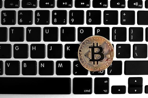 Gouden Bitcoin-muntstuk op het laptop toetsenbord. Handel concept